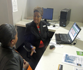 Kisha Boyd-Clyburn, facilitator of program overviews at Central Piedmont Community College (R), discusses training opportunities with Charlotte Works client Monique Hagins.