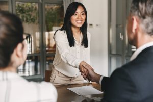 A female business professional is shaking hands with her employer as she starts a new career.